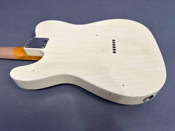 White electric guitar body with visible vintage-style checking and neck plate on dark gray background