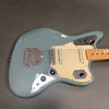 Seafoam green electric guitar with maple neck, cream pickguard, and chrome hardware on a gray background