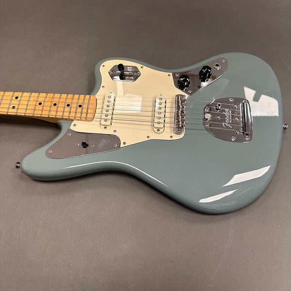 Seafoam green Fender electric guitar with maple neck and dual single-coil pickups on gray background