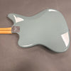 Back view of light gray Fender electric guitar body with maple neck and chrome Fender Custom Shop neck plate on gray background