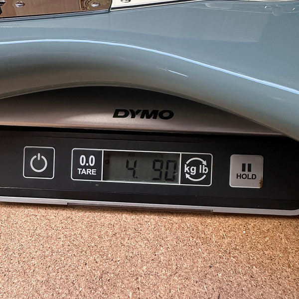 Close-up of digital scale showing weight of electric guitar at 4.90 pounds on DYMO scale for Coffee House Guitars product listing.