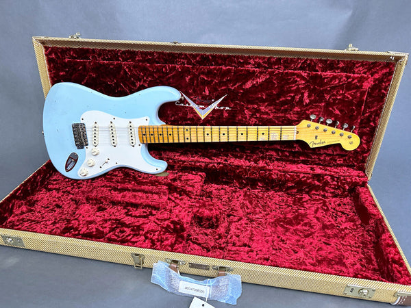 1965 Fender Stratocaster electric guitar in light blue finish with maple neck and white pickguard, displayed in vintage tweed hard case with red plush lining, custom shop logo visible inside case.