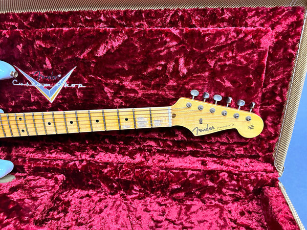 Close-up of Fender Custom Shop Stratocaster maple neck and headstock inside a red velvet-lined tweed guitar case