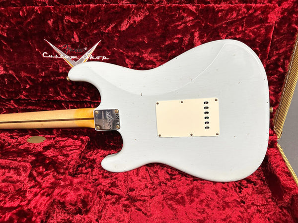 Back view of a white Fender Custom Shop electric guitar with a maple neck, displayed inside a red velvet-lined guitar case.