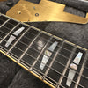 Close-up of guitar fretboard with mother of pearl inlays and metal strings on dark wood, gold pickguard with "Professional" engraving in background on black case lining.