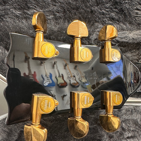 Close-up of Yamaha guitar headstock back with gold tuning pegs and serial number made in Japan