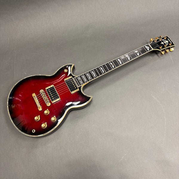 Yamaha electric guitar with cherry sunburst finish, gold hardware, dual humbucker pickups, and decorative inlays on the fretboard, displayed on gray background.