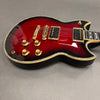 Electric guitar with red sunburst finish, gold hardware, dual humbucker pickups, and cream binding on body edges