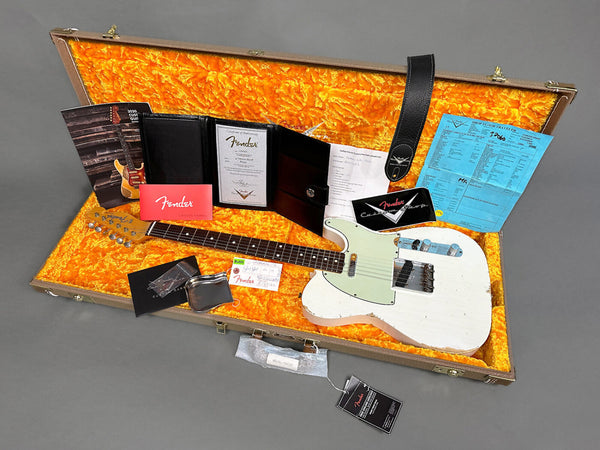 Fender Vintage White Telecaster guitar with worn finish in open hard case with orange plush interior, including Fender certificate of authenticity, owner's manual, strap, inspection card, and paperwork