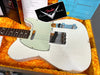 Vintage white Fender Telecaster electric guitar with aged finish and rosewood fretboard in orange plush-lined hard case with Fender Custom Shop card and setup notes