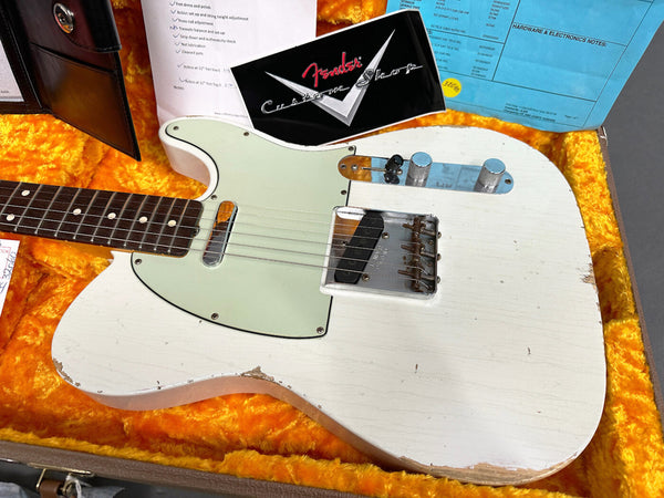 Vintage white Fender Telecaster electric guitar with aged finish and rosewood fretboard in orange plush-lined hard case with Fender Custom Shop card and setup notes