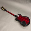 Back view of red and black electric guitar with gold tuning pegs on gray background