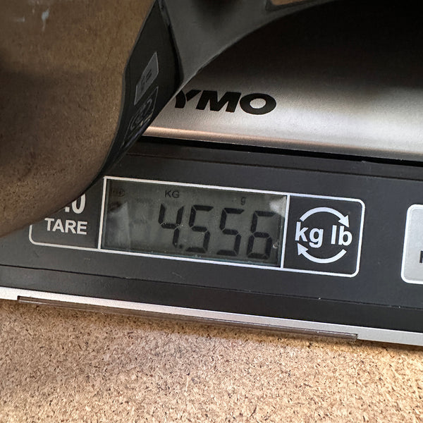 Close-up of digital scale showing a guitar weight of 4.556 kilograms at Coffee House Guitars product listing.