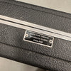 Close-up of a Hiscox guitar case label made for Yamaha, black textured exterior with metal trim.