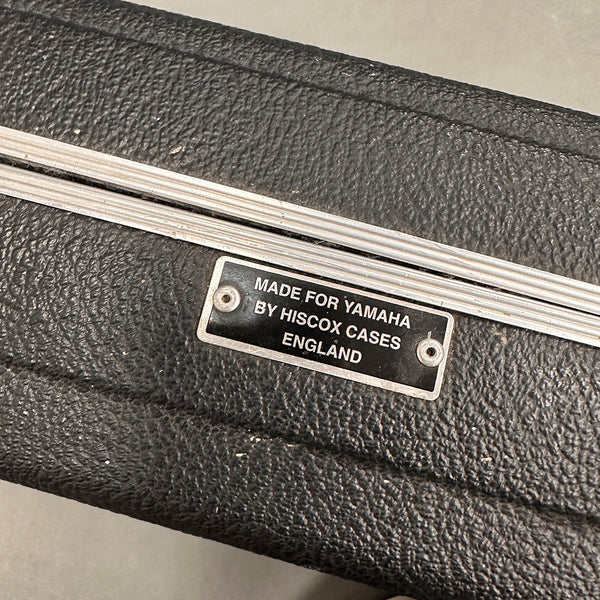 Close-up of a Hiscox guitar case label made for Yamaha, black textured exterior with metal trim.