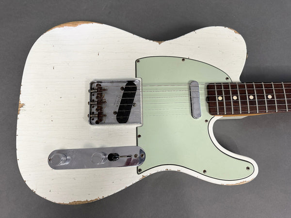 Vintage white Fender Telecaster electric guitar with worn finish, mint green pickguard, and rosewood fingerboard, shown from front angle on gray background