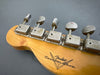 Close-up of vintage Fender Custom Shop guitar headstock showing aged tuning pegs and logo on natural wood finish