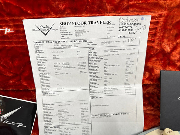 Fender Custom Shop Shop Floor Traveler spec sheet for 1956 Stratocaster Journeyman Relic guitar with Sonic Blue finish and ash body on orange plush background