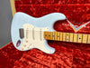 Light blue Fender Stratocaster electric guitar with maple neck and vintage white pickguard in open red plush Fender Custom Shop guitar case