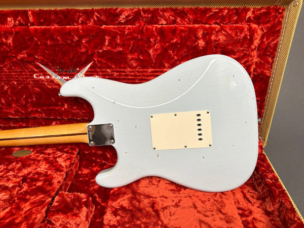 Back view of white Fender Stratocaster electric guitar with cream backplate and maple neck resting in red velvet-lined Fender Custom Shop tweed case