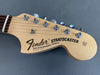 Fender Stratocaster guitar headstock with synchronized tremolo and six tuning pegs on light wood finish against gray background
