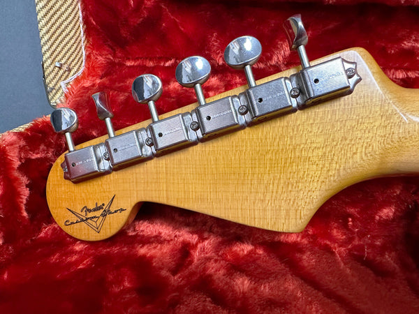 Close-up of Fender Custom Shop Guitar maple neck headstock with vintage tuning pegs on red plush guitar case interior