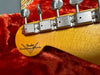 Close-up of Fender Custom Shop electric guitar headstock with vintage tuning machines on red plush guitar case interior