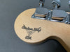 Close-up of Fender Custom Shop USA logo on guitar headstock with chrome tuning pegs