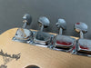 Close-up of chrome tuning pegs on a Fender Custom Shop guitar headstock with natural wood finish