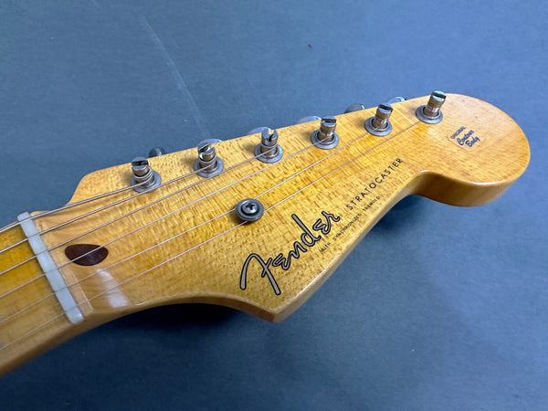 Close-up of Fender Stratocaster electric guitar headstock with six tuning pegs and original contour body logo on natural wood finish
