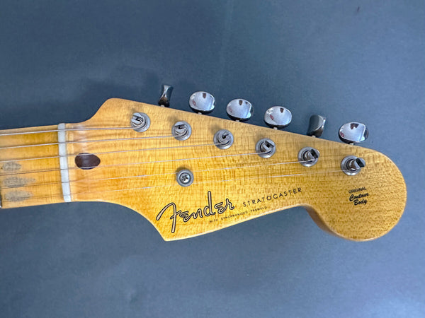 Close-up of vintage Fender Stratocaster guitar headstock with tuning pegs and strings, natural wood finish, original contour body text visible