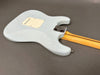 Backside of vintage light blue electric guitar body with cream backplate and maple neck, showing wear and relic details on gray background