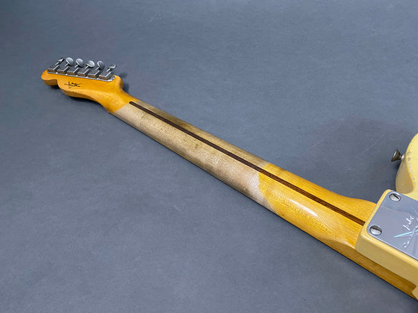 Vintage electric guitar maple neck with worn finish and chrome tuning pegs on gray background