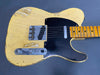 Vintage yellow Fender Telecaster electric guitar with black pickguard and maple neck showing wear and aging on body and fretboard