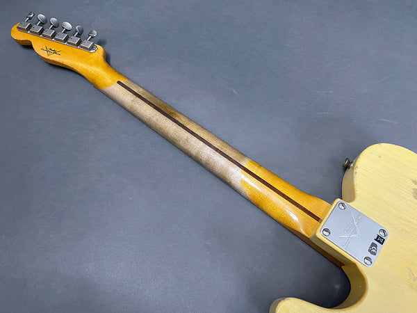 Vintage Fender Telecaster guitar back view showing maple neck with worn finish and metal neck plate on cream-colored body against gray background
