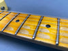 Close-up of worn maple guitar fretboard with metal frets and black dot position markers on electric guitar neck