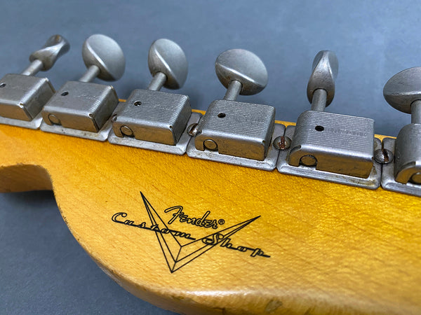Close-up of vintage Fender Custom Shop guitar headstock with vintage tuning pegs and logo on natural wood finish