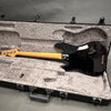 Black Fender electric bass guitar with maple neck in open gray plush-lined hard case, back view
