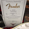 Fender Certificate of Authenticity for 69 Stratocaster NOS with serial number R05871 displaying Fender Custom Shop branding and signature, partially showing white Stratocaster guitar body and tone knob.