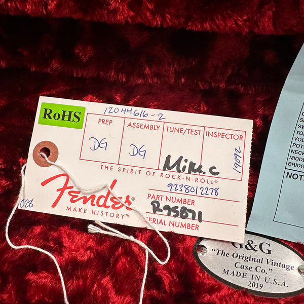 Fender guitar quality control tag and G&G vintage guitar case metal label inside red plush case lining