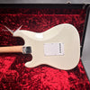Back view of white Fender electric guitar with maple neck in red plush-lined Fender Custom hard case