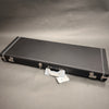 Black Fender hard shell electric guitar case with silver latches and handle on gray background