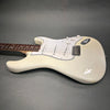 White electric Stratocaster-style guitar with three single-coil pickups, white pickguard, and rosewood fretboard on gray background.