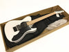 FGN electric guitar with white body, black pickguard, and maple neck inside open cardboard box with black gig bag