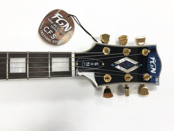 Close-up of FGN electric guitar headstock with gold tuning pegs, mother-of-pearl inlay, and C.F.S. Circle Fretting System tag on a white background