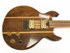 Vintage natural wood finish electric guitar with dual cream humbucker pickups, brass bridge, three control knobs, and maple neck with fretboard.