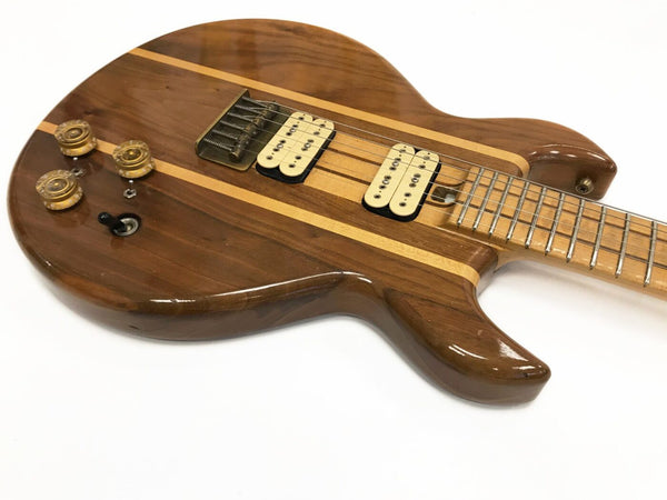Close-up of Coffee House Guitars custom electric guitar with natural wood finish, dual humbucker pickups, maple fretboard, and amber control knobs on white background