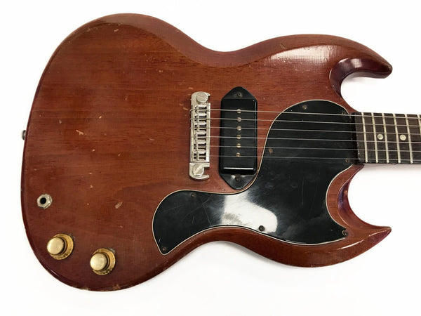 Vintage electric guitar body with worn cherry red finish, single black P-90 pickup, black pickguard, and two cream control knobs on white background