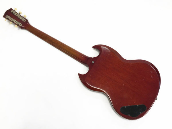 Back view of vintage red electric guitar with double cutaway body and wooden neck on white background