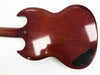Vintage cherry red electric guitar back with worn finish and black plastic control cavity cover on white background